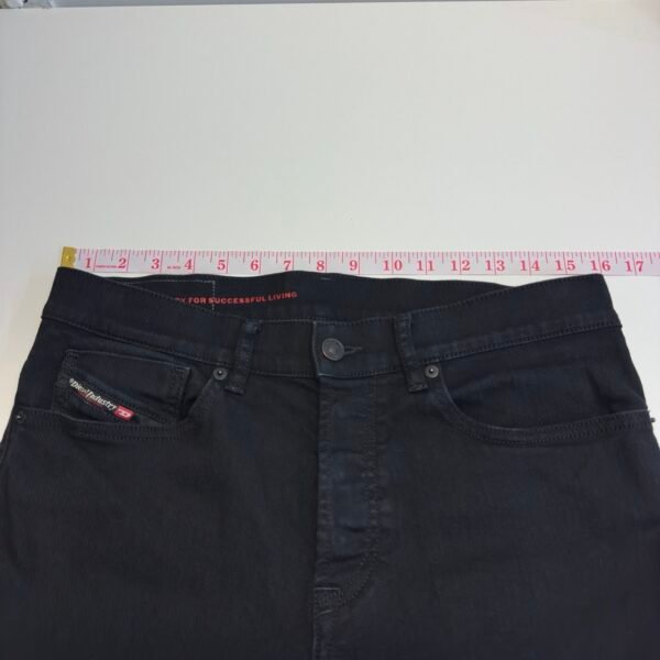 Tape measure across the waist of Diesel 2005 black jeans