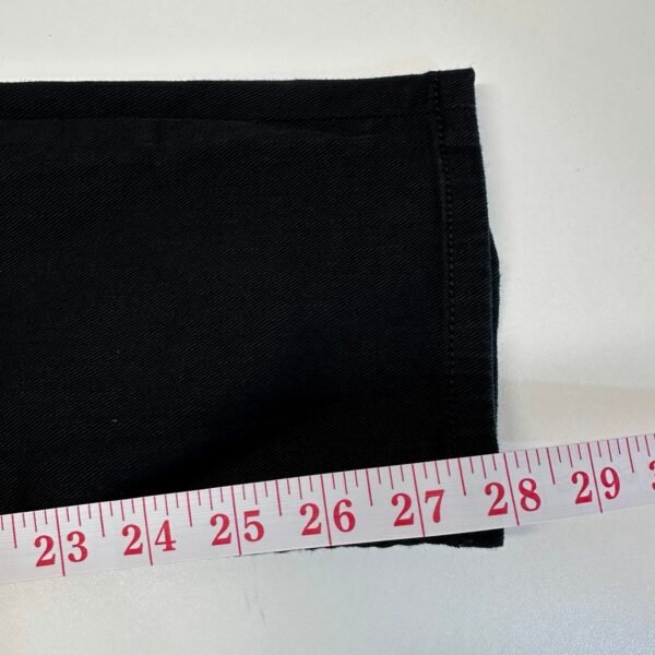 Tape measure beside a leg opening of Diesel 2005 black jeans